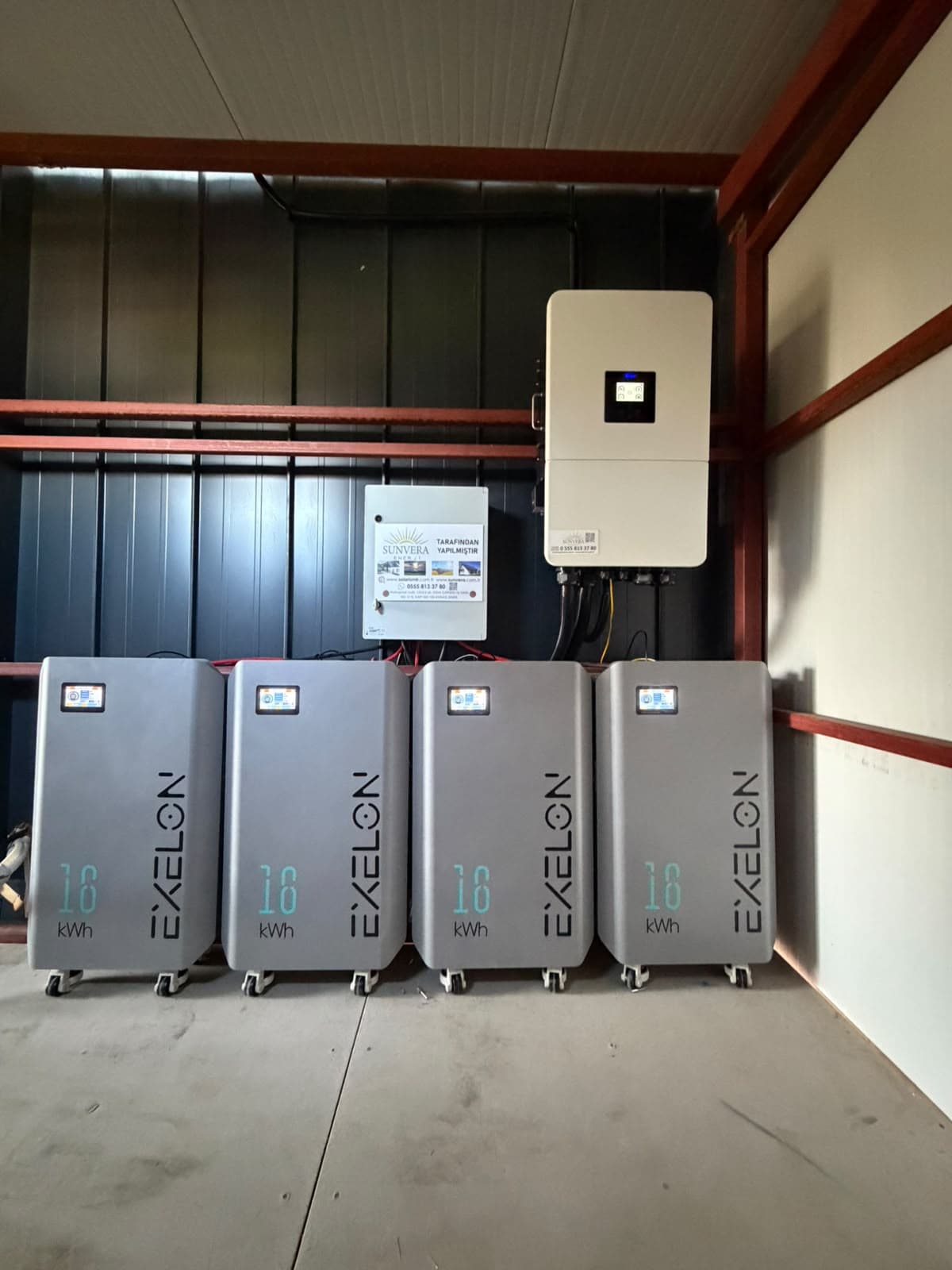 Duvara monte inverter ve altında batarya modülleri